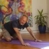 man on hands and knees for an online scaravelli inspired yoga class