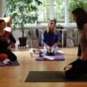 scaravelli inspired yoga workshops image with students surrounding a teacher on the floor with erling.yoga