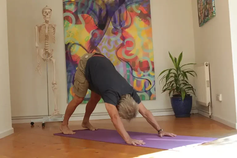 man in down facing dog in yoga foundation course