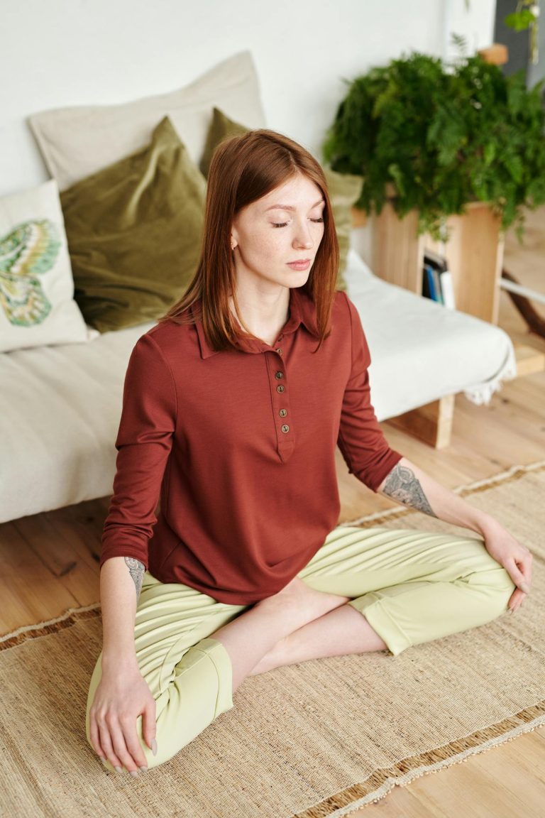 Calm woman practicing yoga meditation on rug in cozy home setting.