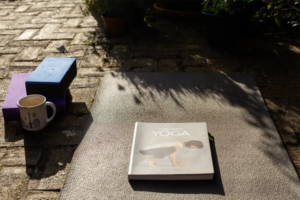 Understanding Yoga Poses Through Functional Movement Patterns Yoga with Erling tea mug, yoga blocks and mat and yoga book for a blog on yoga poses